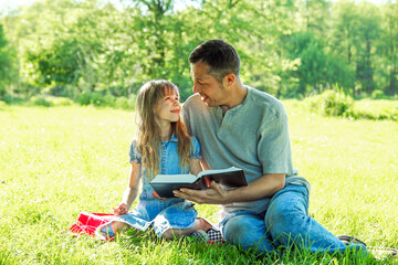 young father with a  daughter reading the Bible