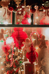 Christmas toys with bright garlands behind glass