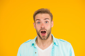 surprised guy with unshaven face. expressing human emotions. bearded sexy man wearing casual shirt. male spring fashion style. mens facial care and beauty. having trendy haircut