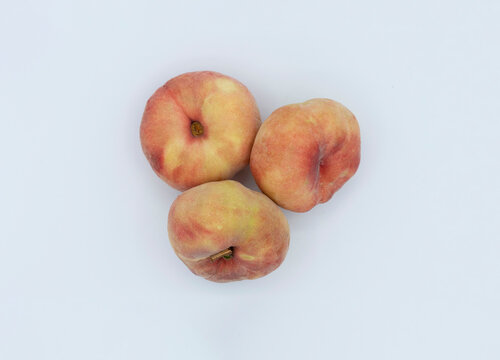 THREE PIECES OF FRUIT CALLED PARAGUAYAS  ON A WHITE BACKGROUND