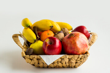 Mixed,fresh  fruits in wicker basket on white background,