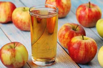 Glasses with apple juice and ripe apples