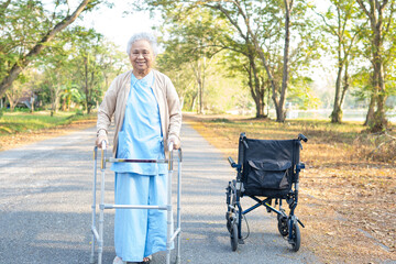 Asian senior or elderly old lady woman use walker with strong health while walking at park in happy holiday