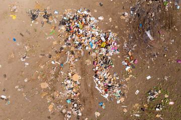 Piles of trash scattered in a large field, Aerial view.