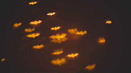 defocused bokeh gold lights in shape of bats for halloween background - holidays, decoration and...