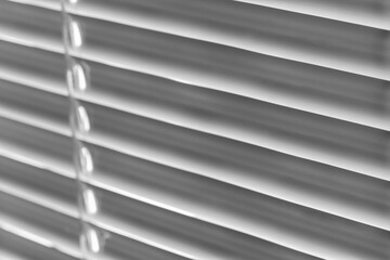 Fototapeta premium White jalousie background. Closeup, selective focus, black and white photo