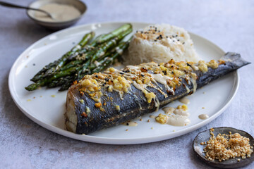 Baked sea bass with lemon grass, ginger, tahini sauce and sesame seeds