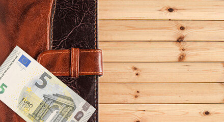 Organizer brown and euro, on a wooden background. Place for your text.
