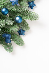 Christmas background. Blue decorations on spruce branches on a white background. Christmas Flatly. Top view from copyspace