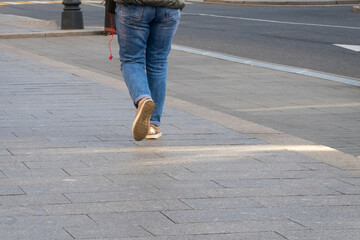 Sidewalk. Woman legs walking, motion blur. Selective focus. Copy space.