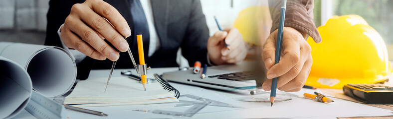 Two colleagues discussing data working and tablet, laptop with on on architectural project at construction site at desk in office