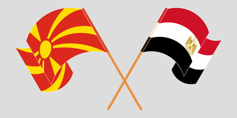 Crossed and waving flags of North Macedonia and Egypt