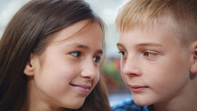 Close up portrait of happy kids looking at each other and smiling