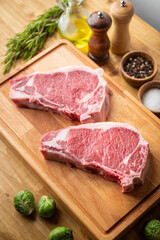 raw steak meat on cutting board in bright kitchen