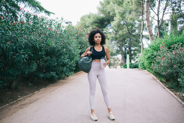 Confident ethnic woman standing in park