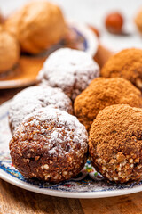 Healthy homemade paleo chocolate energy balls with nuts, dates and cocoa close-up. Homemade chocolate round candies. Sweet food with nuts.