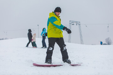man snowboarding down by hill