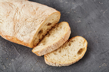 Bakery - gold rustic crusty loaves of bread and buns on grey chalkboard background.