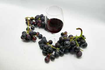 copa de vino rodeada de uvas en un fondo blanco