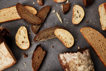 Bakery - gold rustic crusty loaves of bread and buns on grey chalkboard background.