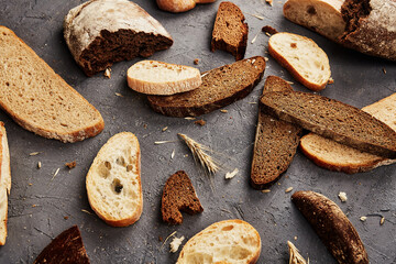 Bakery - gold rustic crusty loaves of bread and buns on grey chalkboard background.