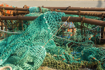 colorful nets and rusty fishing gear on a quay in the harbor of Ostend, Belgium