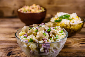 Set of festive mayonnaise salads on wooden table