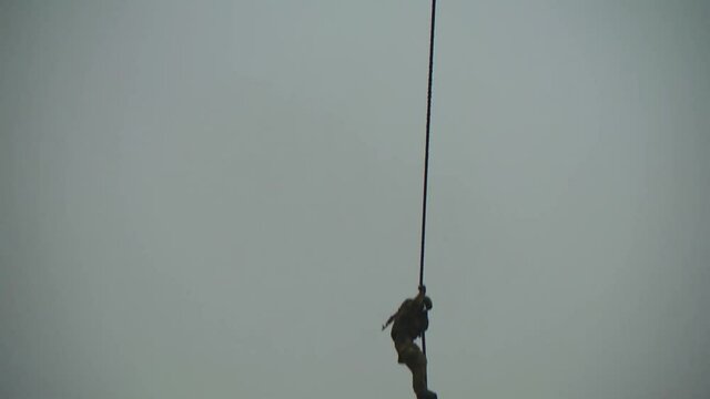 Landing without a parachute from a helicopter. Military paratroopers descend the cable.