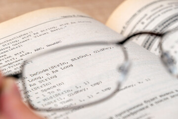 View through glasses in hand on a text in the book