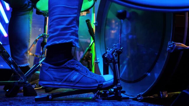 Drummer of a rock band plays the bass drum on stage