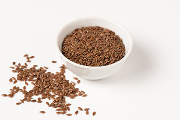 Raw flax seeds in ceramic bowl on white background for Superfood and diet product concept