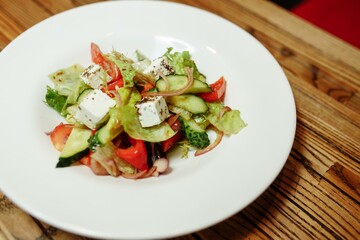 Greek salad on wooden background top view. Space for text. Healthy food