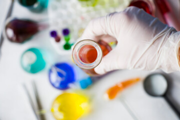 Laboratory instruments, glassware and reagents, colorful liquid chemical elements, doctors hand