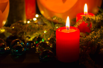 A thin wax candle with a small lit flame with a background. Candles on an old table. Beautiful background. Religious concept.