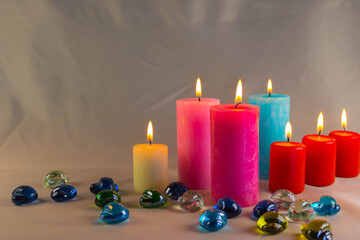 A thin wax candle with a small lit flame with a background. Candles on an old table. Beautiful background. Religious concept.