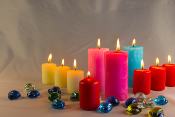 A thin wax candle with a small lit flame with a background. Candles on an old table. Beautiful background. Religious concept.