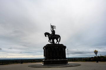 bronze rider in a park on top of a hill against a gray sky