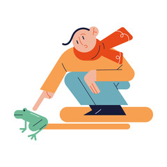 Child sitting and playing with frog outdoors in autumn