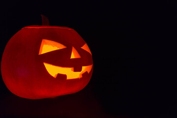 Halloween pumpkin. Candles, bat and glowing pumpkin. Harvest for Halloween. Dark atmosphere for holiday.