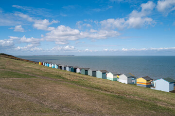 A row of colourful beach huts along the sea front in Tankerton, Whitstable.