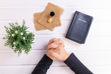 Young woman praying and Taking communion  - the wine and the bread symbols of Jesus Christ blood and body with Holy Bible