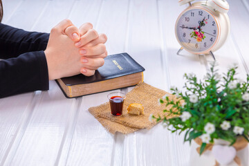 Young woman praying and Taking communion  - the wine and the bread symbols of Jesus Christ blood and body with Holy Bible