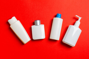 Set of White Cosmetic containers isolated on colored background, top view with copy space. Group of plastic bodycare bottle containers with empty space for you design