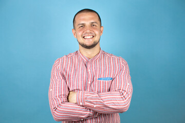 Russian business man over blue background smiling crossing arm and looking at the camera