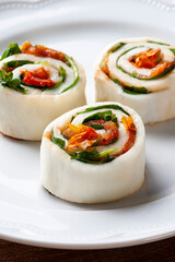 .Buffalo mozzarella roll stuffed with dried tomatoes and arugula.