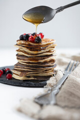Plate with pancakes and berries on white table