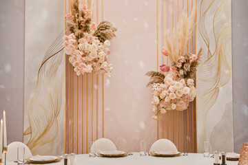 Close up of centerpiece at wedding reception. wedding decor, flowers, pink and gold decor, candles. Festive table decor.
