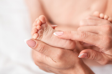 Fototapeta na wymiar Mother hand massaging leg and foot muscle of her baby, touch of happiness, health care concept