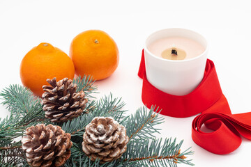 Christmas composition on a white background. Christmas cones, candle and a sprig of Christmas tree.