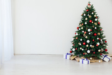Christmas tree with gifts for the new year in the interior of the white room